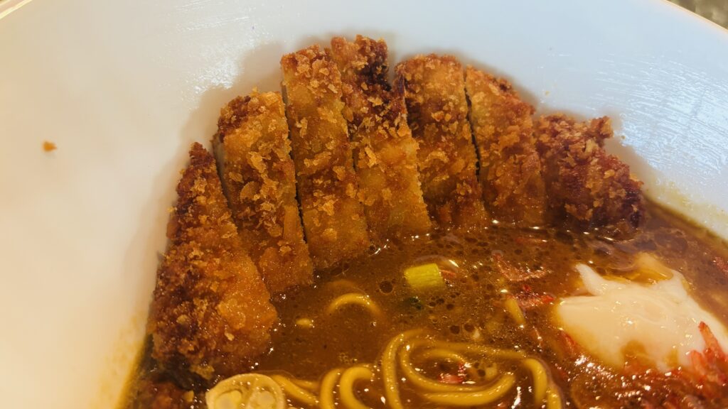 チキンカツミソカレーラーメンのアップ。揚げたてのチキンカツと半熟卵