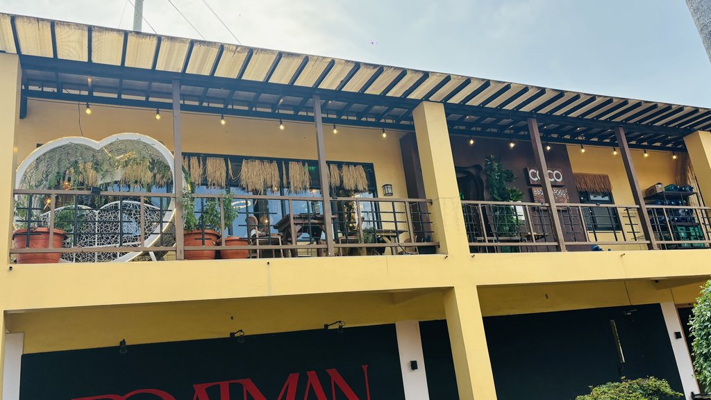 黄色い2階建ての建物。2階のテラスにCoco Cebuの看板が見える