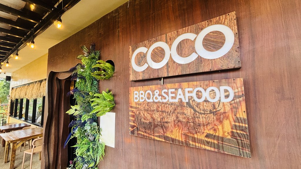 木の壁にかかった「COCO」「BBQ&SEAFOOD」の看板