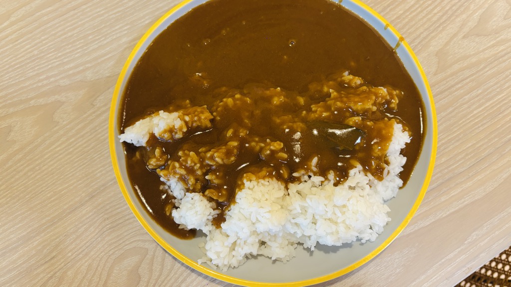 お皿のご飯に、茶色いカレーのルーをかけたところ