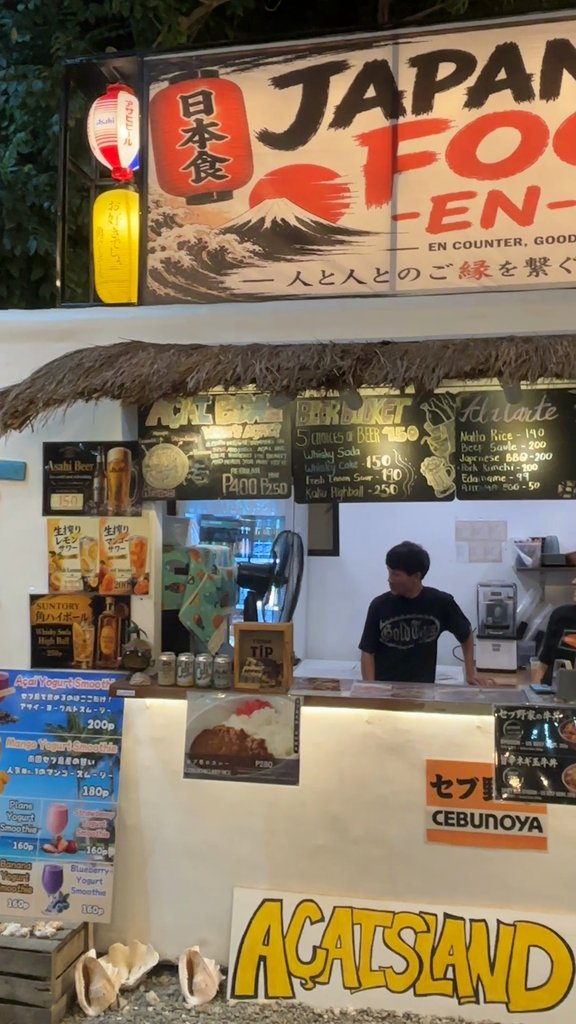 『縁 -EN-』のカウンター。おつまみやビールバケツの黒板と、AÇAISLANDのスムージーのメニュー
