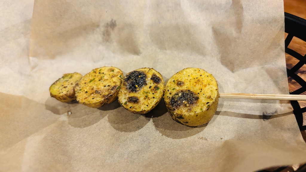 焼き目のついたじゃがいもを4つ刺したじゃがバターの串