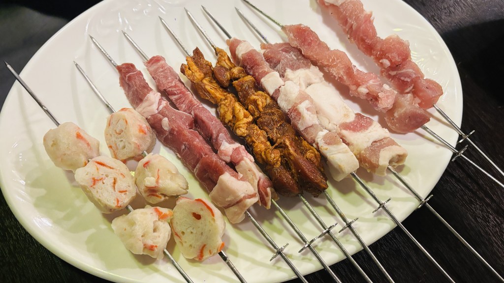 お皿に並んだ焼く前の串。魚のすり身、赤身の肉、豚バラなど