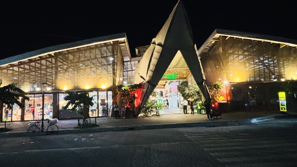 三角屋根のPusô Villageの建物。夜のライトアップで明るく光る入口