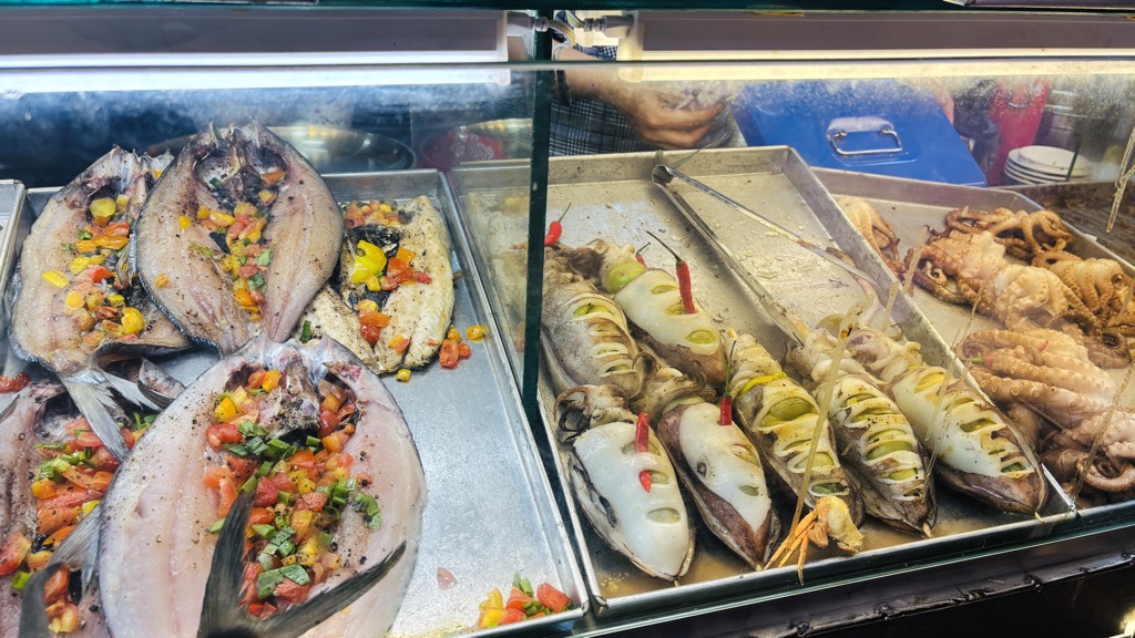 ショーケースに並ぶ焼き魚やイカの丸焼き