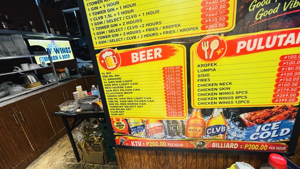 ON D' WINGSのビールとおつまみの値段の看板。KTV・ビリヤード1時間200ペソ