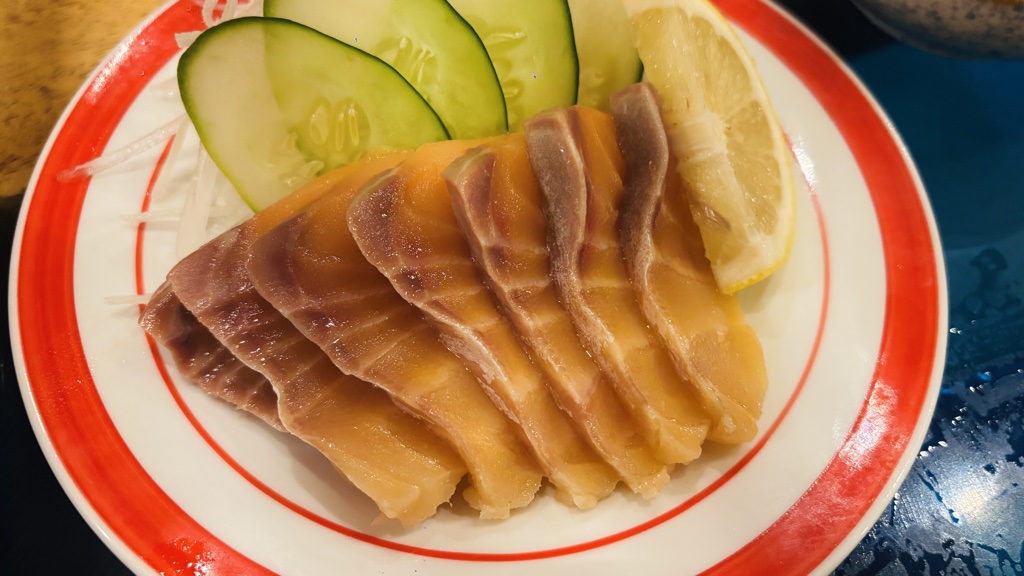 サーモンの刺身。きゅうりとレモン、大根のつま添え
