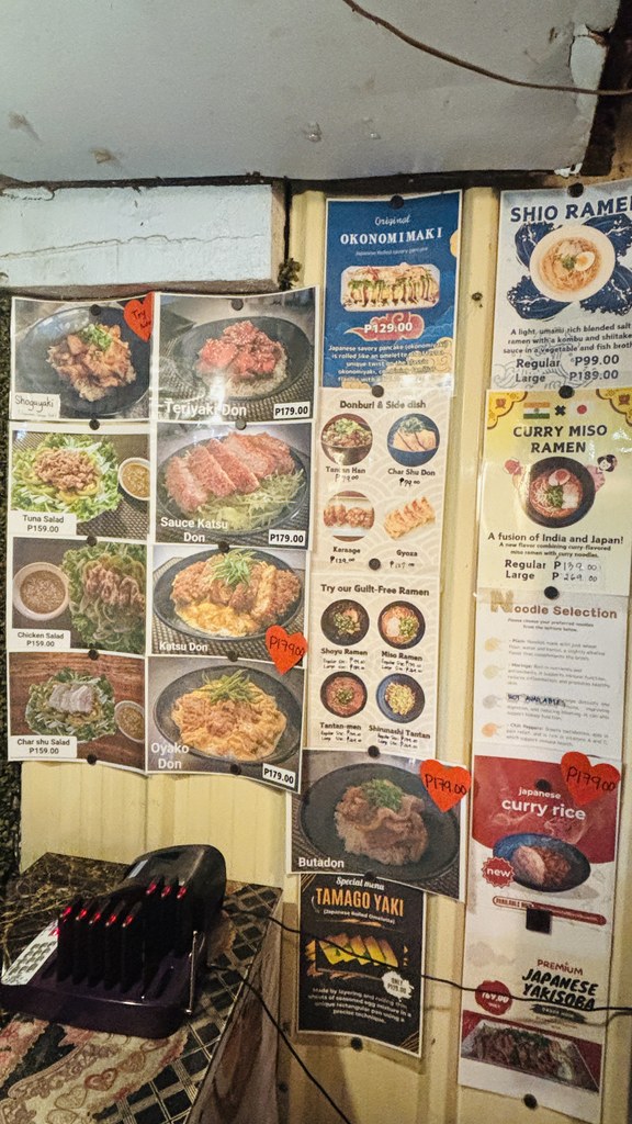 壁に貼られたメニューのポスター（お好み焼き、塩ラーメン、カレー味噌ラーメン、カレーライスなど）