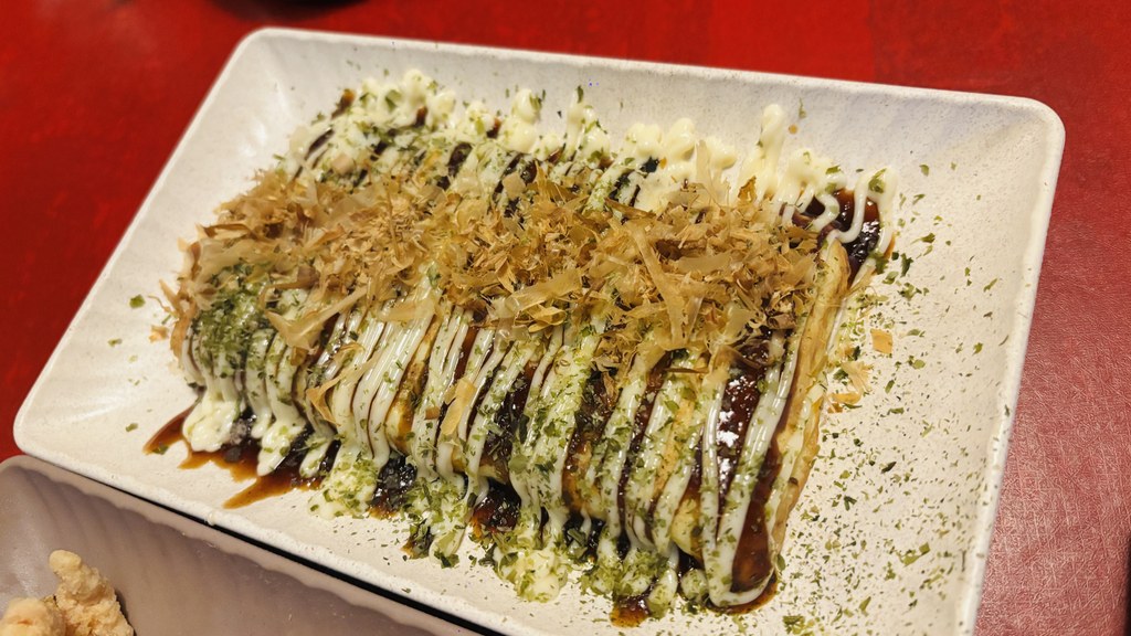 ソース、マヨネーズ、かつお節、青のりがかかったお好み焼き（オコノミマキ）
